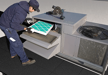 Worker changing filter on rooftop AC unit